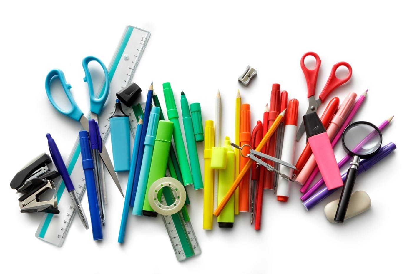coloured-pens-stationary Scattered coloured pens and various stationery items spread across a desk