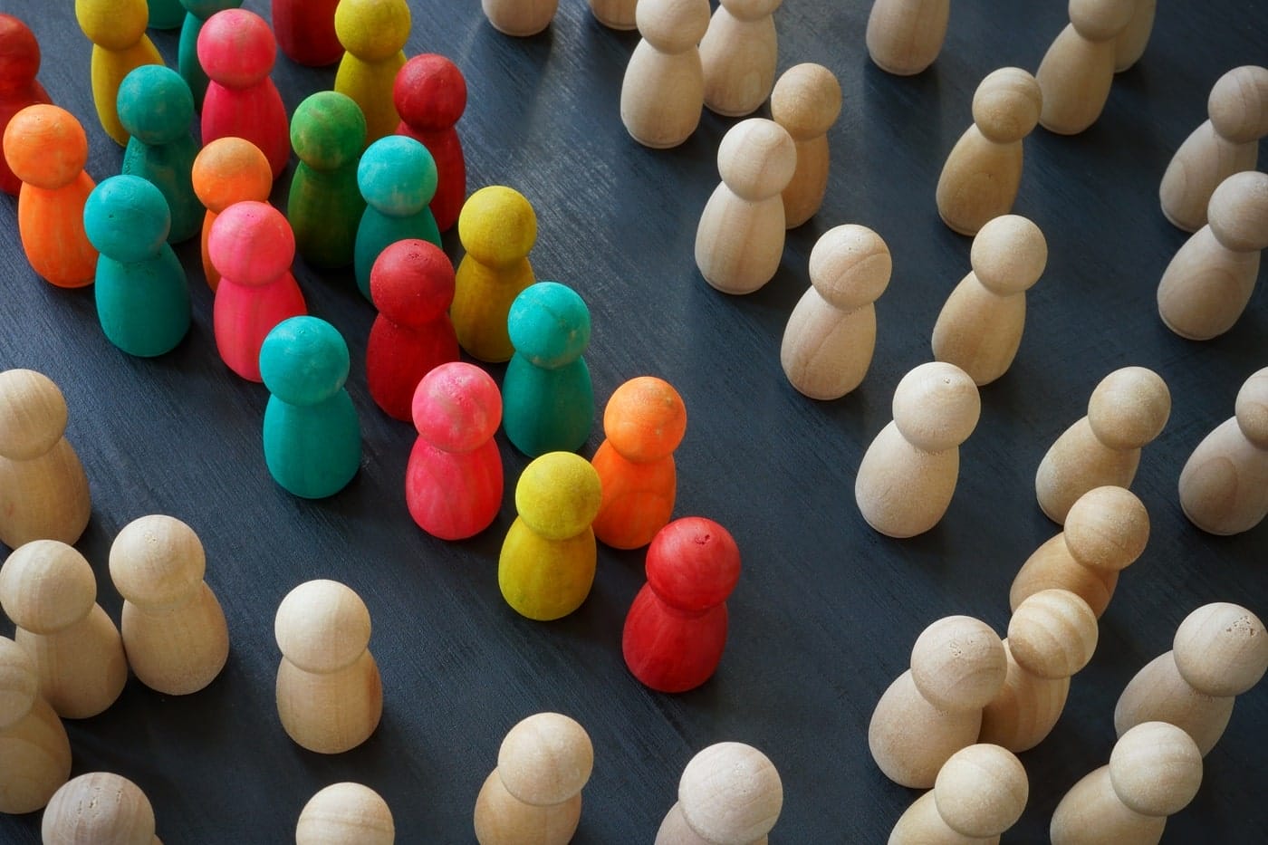 wooden-figures-with-human-form-some-colour Wooden human figures in varied colors, representing diversity, inclusion, and community voices in participatory design.